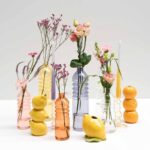 Zitronenvase in Zitronenform auf einem Tisch mit sommerlicher Deko, veranschaulicht die Einsatzmöglichkeiten.